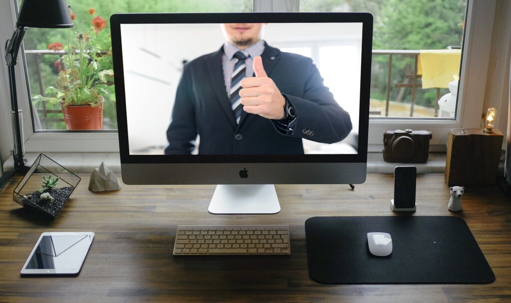 Man holding a thumbs up during a virtual event or webinar